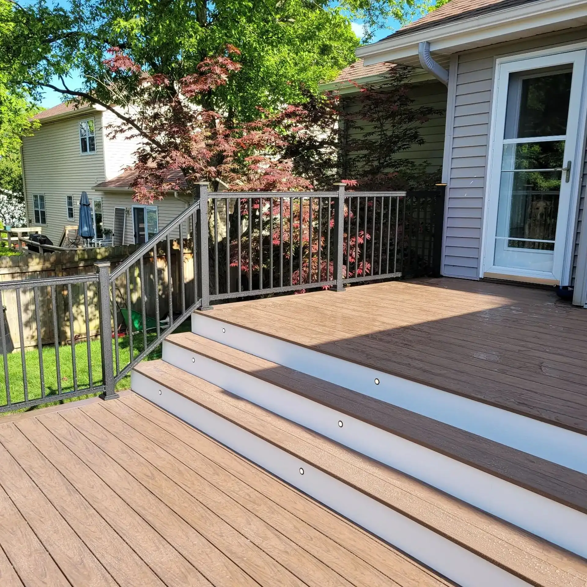 Composite deck steps with step lights and metal railing